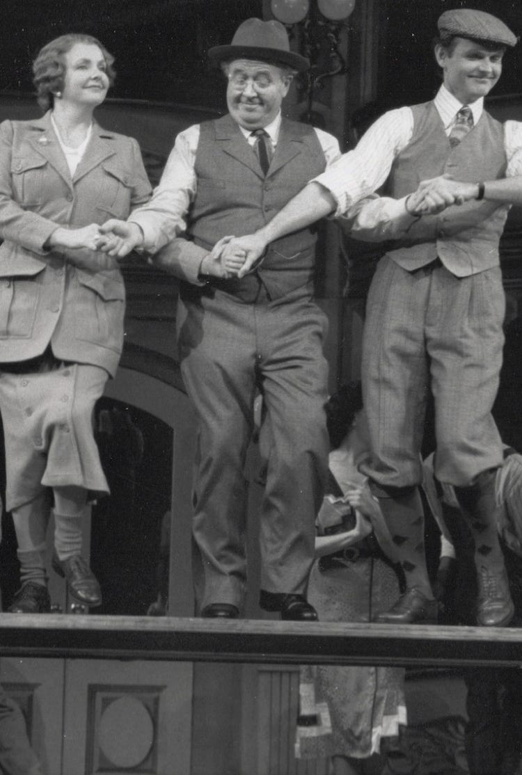 A production Photo from the musical Crazy For You; Stephen Temperley as Eugene Fodor, dancing on a table with Ronn Carrol and Amelia White